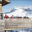 Voll besetzter Balkon eines Lokals auf der Balmalpe Lech in den Vorarlberger Bergen im Winter
