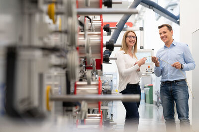 Ein weiblicher Lehrling mit einem Mitarbeiter in industrieller Umgebung bei Rosendahlnextrom