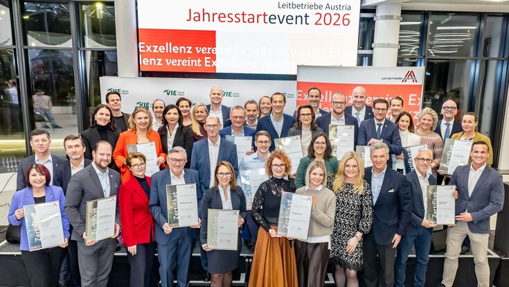 Die ZertifikatsempfängerInnen beim Leitbetriebe Austria Jahresstartevent 2026 halten ihre Zertifikate in die Kamera.