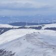 das lavanttal im winter mit windrädern in der ferne