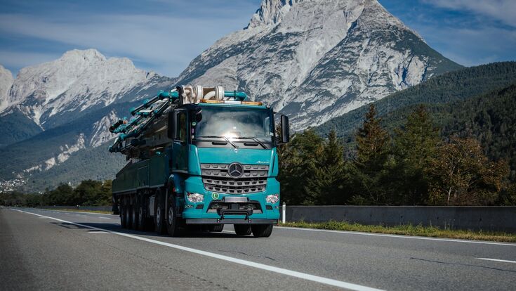 LKW auf Straße mit Bergen im Hintergrund