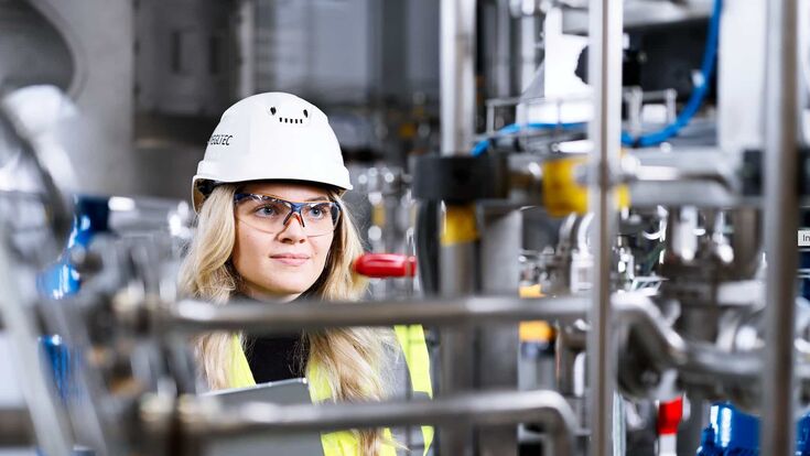 junge mitarbeiterin in schutzkleidung im betrieb beim tiroler industrieunternehmen SPIEGLTEC