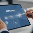 hände einer person führen auf tablet eine patentanmeldung durch