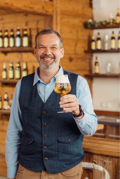 Niki Riegler, Eigentümer und Geschäftsführer der Privatbrauerei Hirt,  mit einem Bierglas in der Hand
