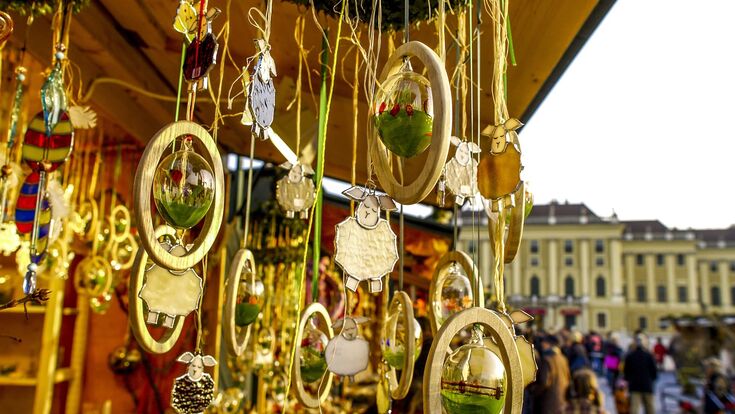 detail eines ostermarkt-standes mit holz-osterschmuck, im Hintergrund schloss schönbrunn in wien