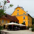 heurigentische und sonnenschirme vor schloss gamlitz in der steiermark