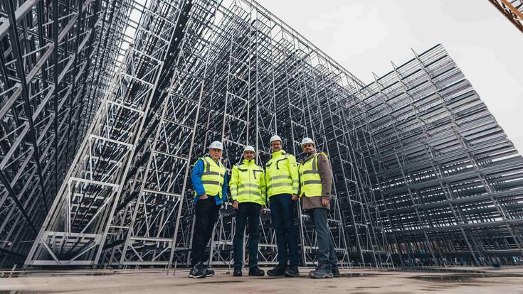 Josef Simon, Vorstand der NÖM AG; Gerald Klein & Roland Stichauner, Geschäftsführer der voestalpine Krems Finaltechnik GmbH und Christoph Posawetz, Projektleiter Logistik der Frischlogistik & Handel GmbH stehen vor im Bau befindlichen Hochregallager