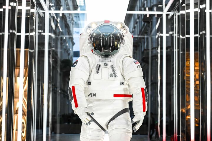 Frontansicht auf einen gehenden Astronauten in komplettem weißen NASA-Raumanzug mit geschlossenem Helm