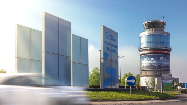 Außenansicht auf Flughafen Graz im Anfahrtsbereich bei blauem Himmel