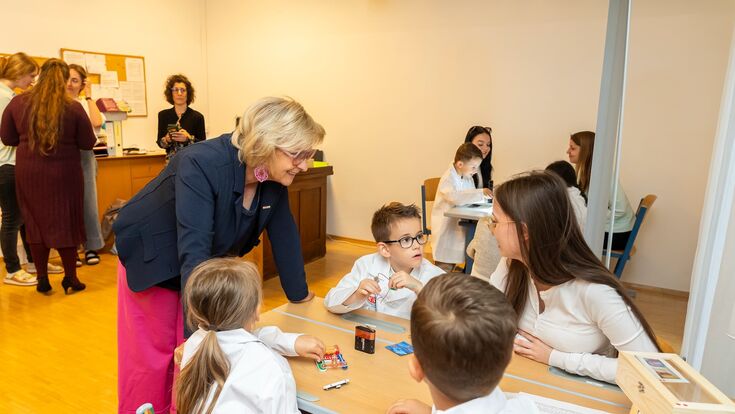 kinder sitzen bei grazer spürnasenecke um einen tisch, WKO Steiermark Vizepräsidentin Gabi Lechner steht dabei