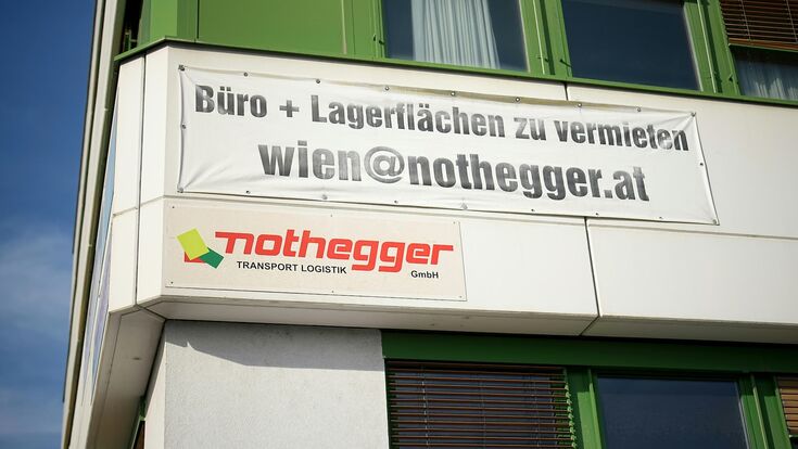 transparent außen auf gebäude, das büro- und lagerflächen zum mieten anbietet, darunter ein firmenschild von nothegger transporte