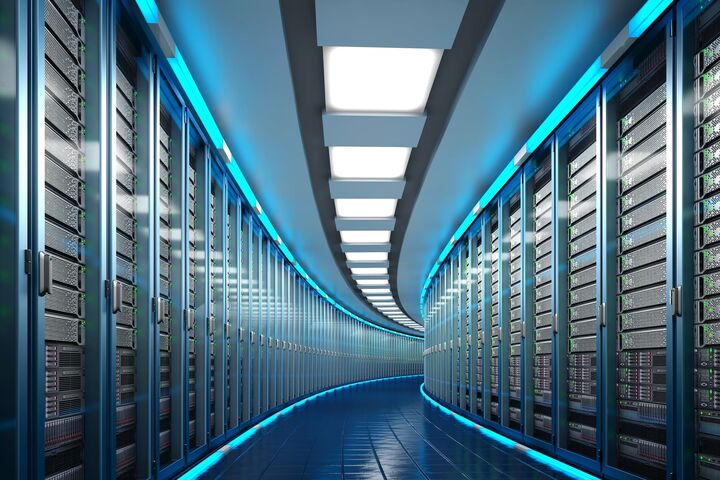 leicht gebogener abschnitt eines gangs in riesigem, blau leuchtenden data center