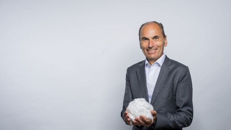 Georg Kasperkovitz, CEO der Lenzing Gruppe, mit einem weißen Ball zellstoff in der hand