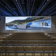 Frontalansicht auf viele leere Sesselreihen vor riesiger LED-Panoramawall im Plenarsaal des Congress Centrum Alpbach