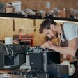 mann repariert in unaufgeräumtem umfeld eine kaffeemaschine