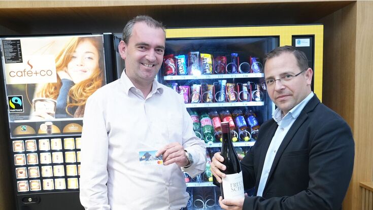 Herbert Oschep von Wein Burgenland und Andreas Wirth, Wirtschschaftskammer Burgenland, stehen mit Bankomatkarte und Weinflasche vor einem Getränkeautomaten