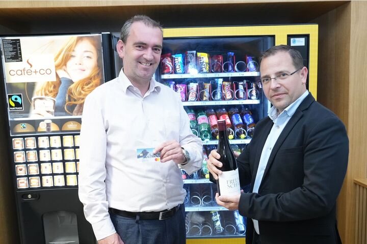 Herbert Oschep von Wein Burgenland und Andreas Wirth, Wirtschschaftskammer Burgenland, stehen mit Bankomatkarte und Weinflasche vor einem Getränkeautomaten