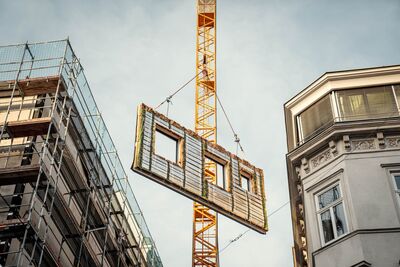 Montage durch Kran der vorgefertigten Fassadenelemente vom Renowate an Haus in Wien