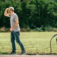 mann sucht mit an ladekabel angeschlossenes e-auto nach ladestation