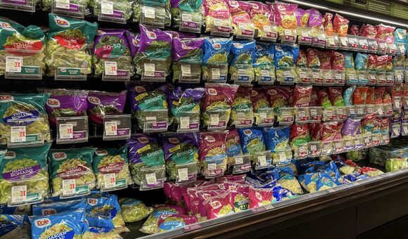 regalreihe in kühlabteilung eines supermarktes voll mit abgepackten salaten