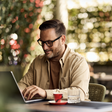mann arbeitet an laptop an einem kaffeehaustisch