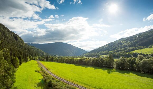 schiene der murtalbahn in üppiger grüner natur