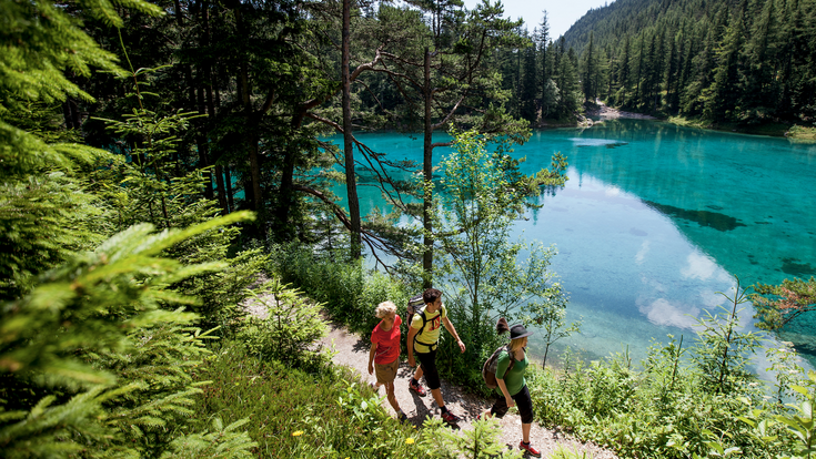ansicht von oben auf 3 junge wanderer am grünen see in der steiermark im sommer